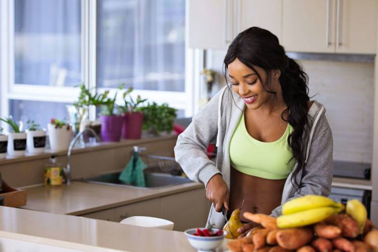 Femme souriante coupant des fruits